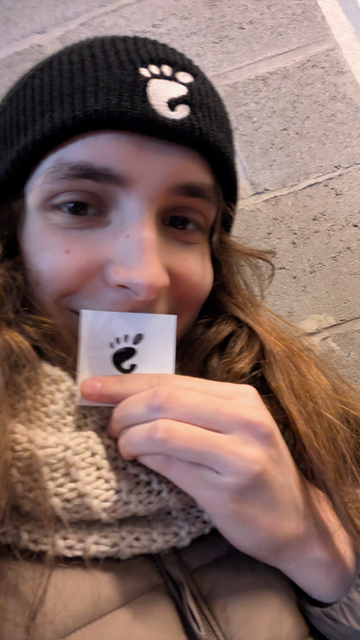 me wearing a gnome hat and holding a gnome logo sticker