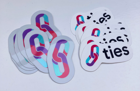 Foto of stickers with the ties logo, which consists of two colorful chain links