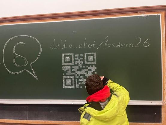 person drawing a QR code on a chalkboard