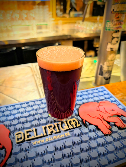 very dark red beer on a Delirium bar mat