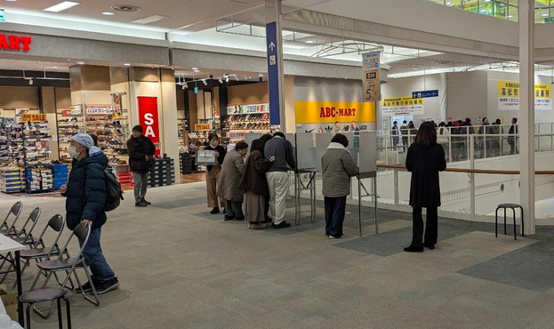 In a shopping mall. In the middle of the picture, people preparing their ballots (I assume, I'm not too sure). In the background, people waiting in line to vote.