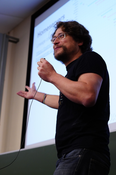 A portrait of Matthew speaking to the audience