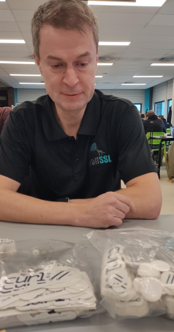 Daniel Stenberg sitting in front of a table with bags of stickers. The sad face is by accident but makes for a funny post
