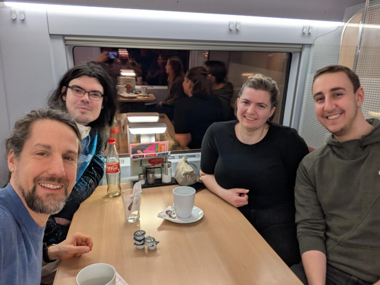 four people at a table on the train