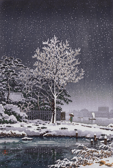 A snowy evening by the Sumida River, in Tokyo. A solitary figure wearing a kimono and carrying an umbrella stands beneath a tall, snow-plastered tree on the banks of the river; nearby, a building is concealed behind a fence, just its roof visible above snowy trees. Small boats travel on the still surface of the cold-looking river beyond, and a layer of fresh snow covers everything, as more snow falls from an overcast sky