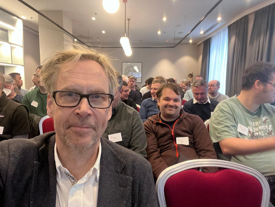 Kaj Arnö in a room with others in the audience attending a presentation at Summit for MySQL Community, Europe.