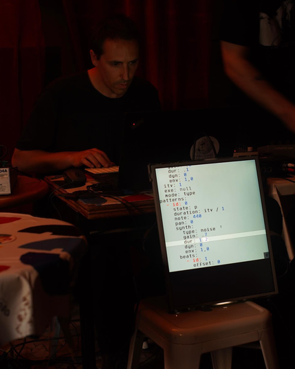 I am live coding music with my custom-made program called été. A vertical screen is placed in front of the public so the code I am performing live can be seen. Photo by David Lantran