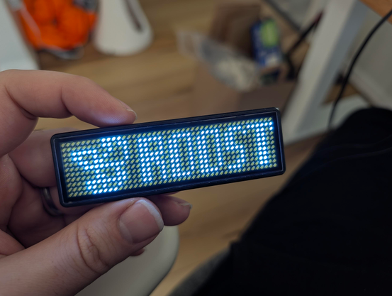 A pixel badge lit up with a pixel art version of the ROOST logo and the word ROOST