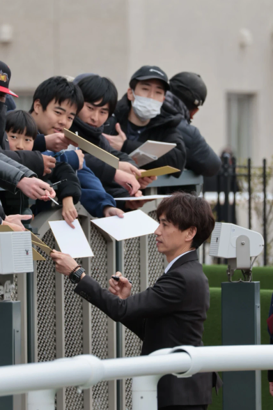 ファンのサインに応じる渡辺薫彦調教師