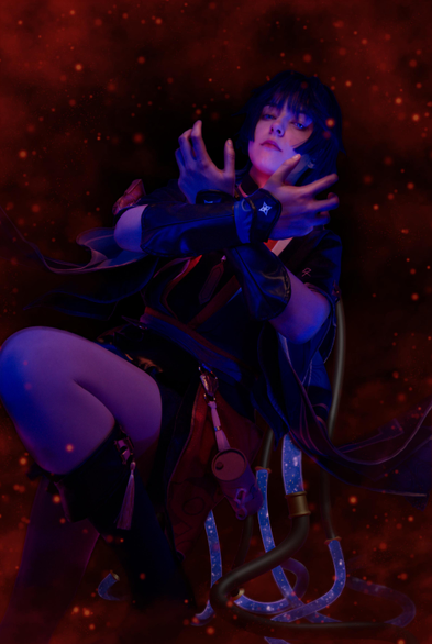 A Scaramouche cosplayer poses with arms crossed over each other in the shape of an "x", their open hands framing their face. They are surrounded by a glowing red smoke-like background with red particles in the air. Behind them are a bunch of curvy tubes that encase a light blue-violet liquid with white particles. The cosplayer's expression is solemn and their gaze piercing.