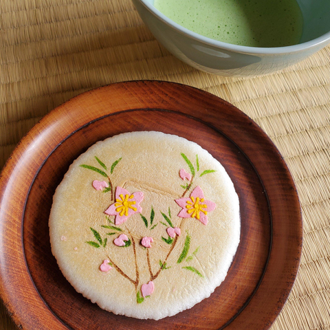 A sweet wafer decorated with iced peach blossoms.