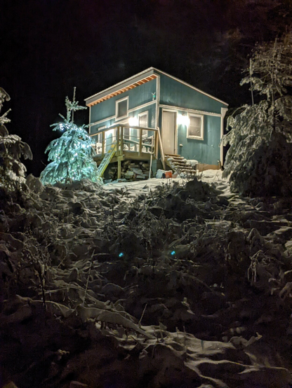 Tiny house at night, blanketed in snow