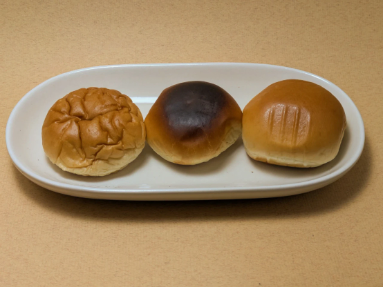 ヤマザキ「薄皮焼そばパン・日清焼そばU.F.O.」が皿の上に3つ並んでいる。左からレンチンしたもの・トースターで焼いたもの・製品そのまま。