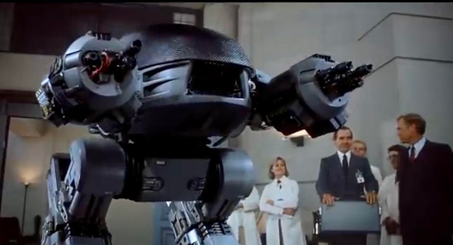 The ED-209 testing at the board meeting scene from 1987 Robocop. 

source https://youtube.com/watch?v=TYsulVXpgYg