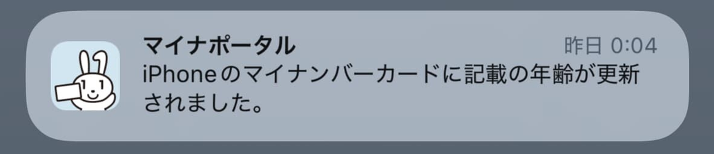 スマートフォンに届いた「マイナポータル」アプリからの通知画面。テキストで「iPhoneのマイナンバーカードに記載の年齢が更新されました。」と表示されており、誕生日に伴う事務的な更新通知であることがわかる。