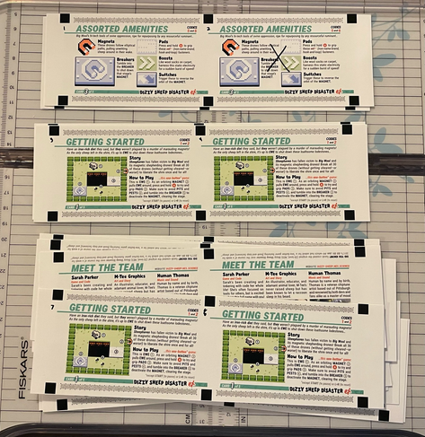 Strips of carefully cut e-reader cards with numbers written in sharpie on top of a cutting board. At the top, one of the cards has a black X over it, suggesting that card was not properly printed.