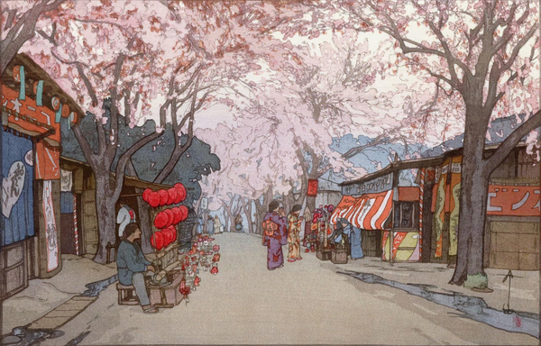 Tall cherry trees full of pale pink blossoms line a narrow avenue of shops, somewhere in Japan. Merchants have set up small stalls on either side of the road; on the right, a pair of female figures in kimono pause before one stall to shop. Screened by the cherry blossoms, the sky above is overcast, the clouds a dull milky colour.
