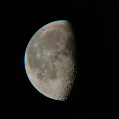 The moon, about half lit so you can see a lot of crater shadows.