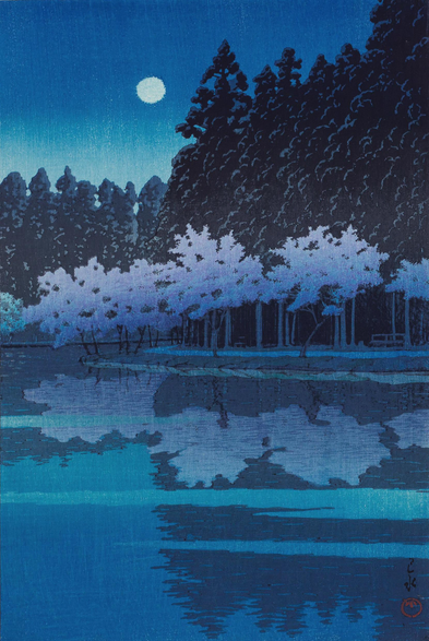 A full moon shines down out of a starless night sky, illuminating a line of cherry trees standing on the shore of the pond in Tokyo's Inokashira Park. It's spring, and the cherry trees are in full bloom, tinted pink in the evening gloom; just behind them, pine trees stand tall and dark in the moonlight. The surface of the pond is still, reflecting the scene.