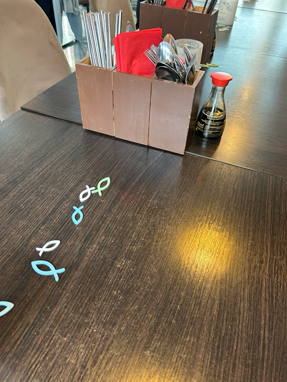 Eine kleine Reihe von Christus-Fischen auf dem Tisch eines japanischen Restaurants.