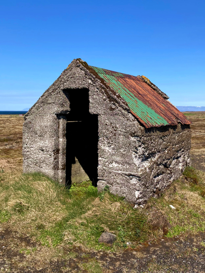 A tiny house with a rusty roof.