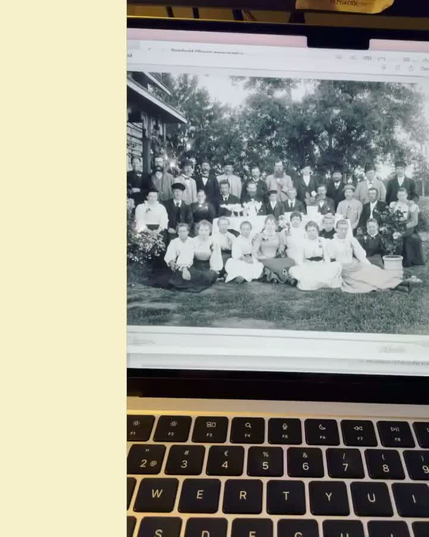 Video taken of a computer screen, zooming in on a black and white picture of a group of people, photo taken at the end of the 1800's. Video ends with zooming in on the small cat sitting on the lap of one of the people. The video has a glittery filter.