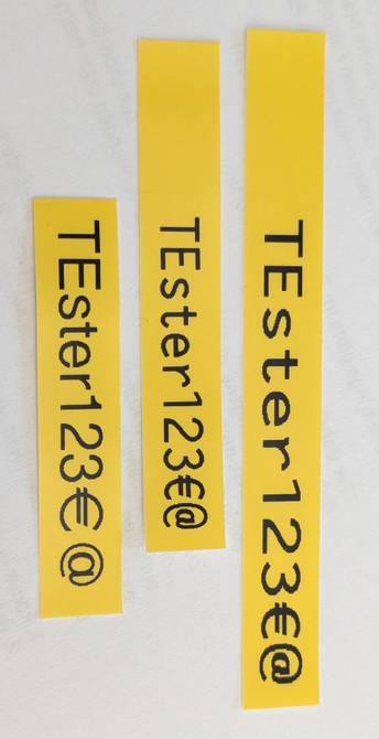 Various test prints with "TEster123€@", the shortest tape is the 7600 print
