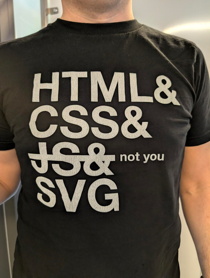 A black shirt with “HTML & CSS & JS & SVG” with JS crossed off and the caption “not you” next to it.