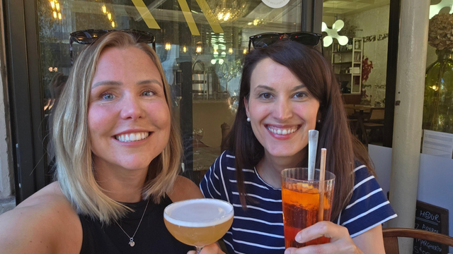 A selfie with me on the left and Elena on the right, both of us holding cocktails and smiling in the camera