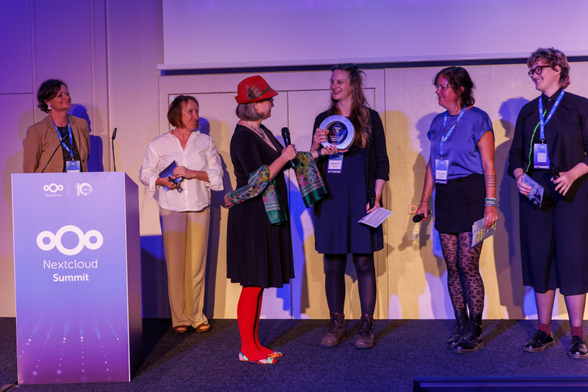 Auf der Bühne bei der Verleihung des Nextcloud Awards 2026 stehen 3 Mitglieder von FREIRAD und erhalten den Award überreicht von Jurymitgliedern. 
c Nextcloud