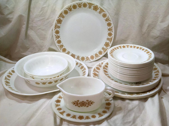 A set of Corelle dining ware from the nineteen seventies. White plates, bowls, et cetera, with a classic Corelle motif in gold around all the edges. It sometime came in dark green, with the same Corelle pattern, but most every family I knew had the gold ones
