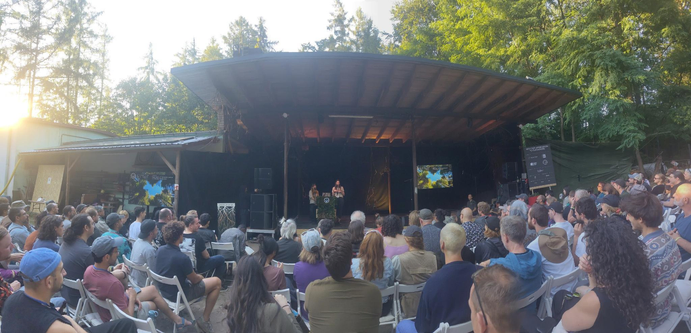 Welcome ceremony at the Dweb Camp by the dweb team; picture with hundreds of people seated in front of the main stage.