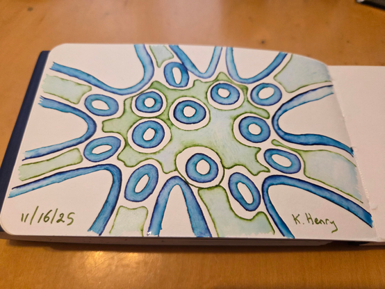Hand drawn generative/procedural art in ink on an open page of my sketchbook.  The abstract pattern is difficult to describe, but has circles in the center and then arcs going off the edges of the page.