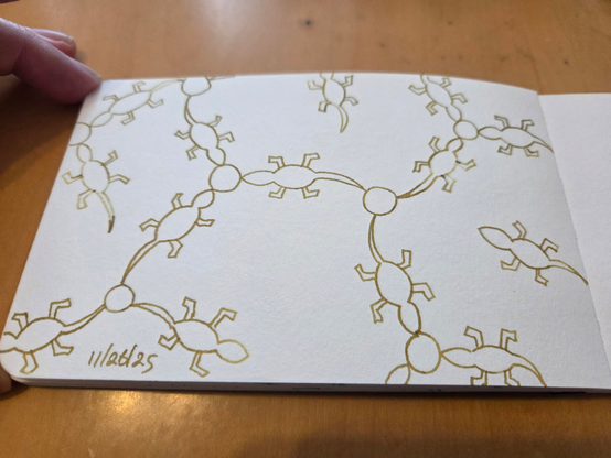 Hand drawn generative/procedural art in ink on an open page of my sketchbook. The abstract pattern looks a bit like a chemistry diagram, but with lizard shapes instead of straight lines.