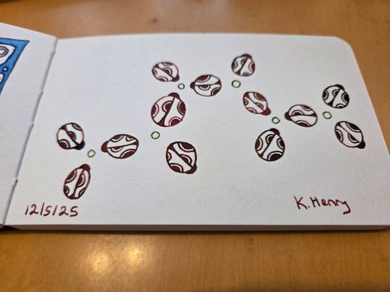 Hand drawn generative/procedural art in ink on an open page of my sketchbook. The abstract pattern looks a bit like a network of ladybugs. Kinda. 