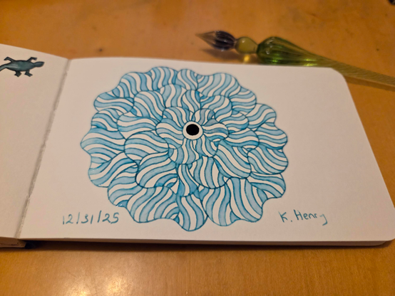 Hand drawn generative/procedural art in ink on an open page of my sketchbook. The abstract pattern is floral. My glass dipping pen is next to my sketchbook.