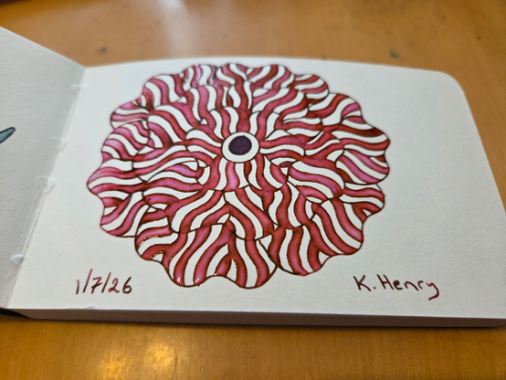 Hand drawn generative art in ink on an open page of my sketchbook. The abstract pattern is floral.