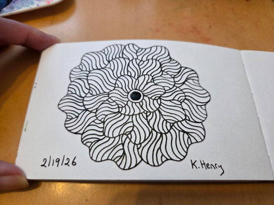 Hand drawn generative/procedural art in ink on an open page of my sketchbook. The abstract pattern is floral.