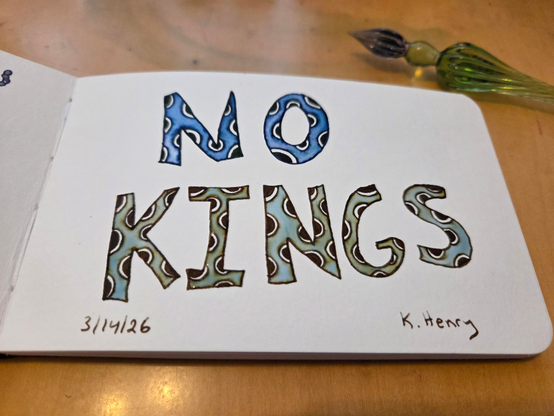 Hand drawn generative/procedural art in ink on an open page of my sketchbook. The pattern is odd letters with polka dots on them. They spell out "NO KINGS". My glass dipping pen is next to my sketchbook.