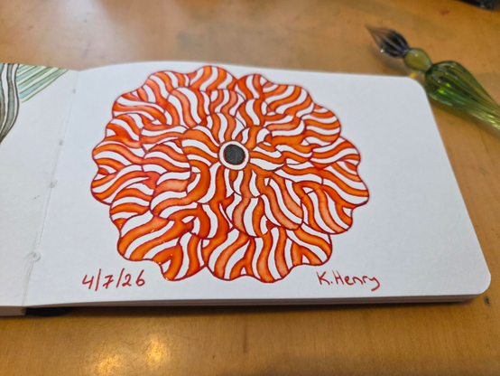 Hand drawn generative/procedural art in ink on an open page of my sketchbook. The abstract pattern is floral. My glass dipping pen is next to my sketchbook.