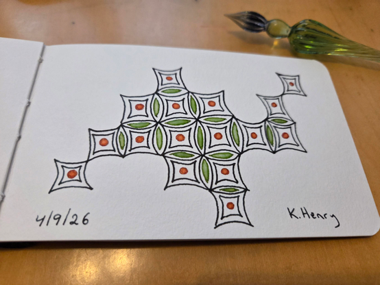 Hand drawn generative/procedural are in ink on an open page of my sketchbook. The abstract pattern looks a bit like an incomplete tiled floor.  My glass dipping pen is next to my sketchbook.