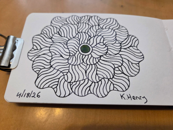 Hand drawn generative/procedural art in ink on an open page of my sketchbook. The abstract pattern is floral. There is a binder clip holding the sketchbook open.