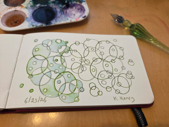 Hand drawn generative/procedural art in ink on an open page of my sketchbook. The abstract pattern is inspired by algae but is just a bunch of overlapping circles of varying sizes. The result is quite pretty, if I may say so.