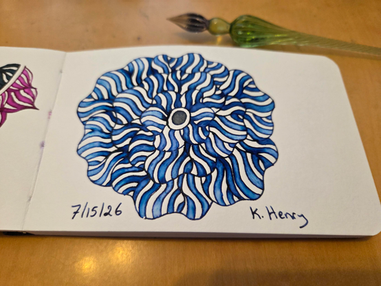 Hand drawn generative/procedural art in ink on an open page of my sketchbook. The abstract pattern is floral. My glass dipping pen is next to my sketchbook.