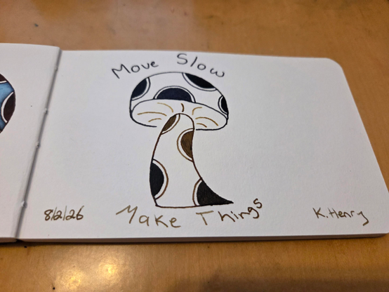 Hand drawn generative/procedural art in ink on an open page of my sketchbook. The pattern looks a bit like a mushroom with polka dots on the stem and cap. There are words above and below the mushroom that read "Move Slow" and "Make Things"