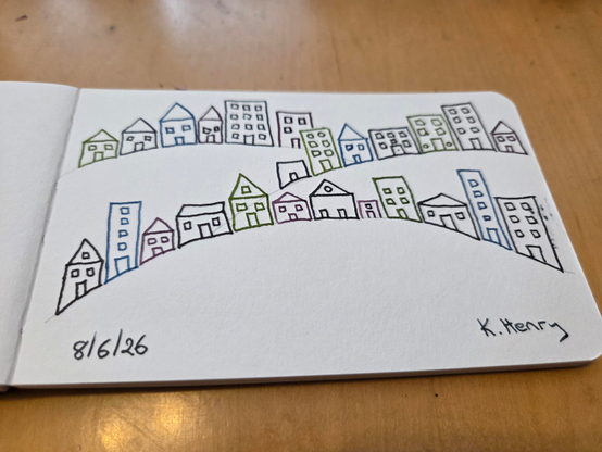 Hand drawn generative/procedural art in ink on an open page of my sketchbook. The abstract pattern looks a bit like houses and apartment buildings on sloping hills.