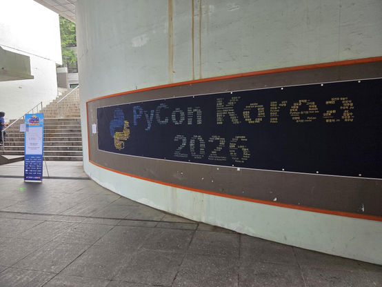 the words "PyCon Korea" on a wall, composed from the names of attendees. 