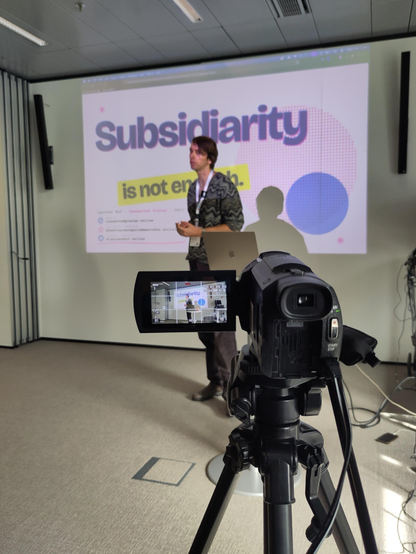 Laurens is giving His Talk at oscl26  - a camera ist filming him